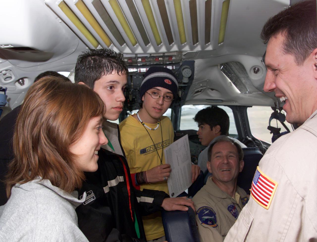 NASA DC-8 Pilots Craig Bomben and Bill Brockett explain the DC-8 cockpit to Chilean students onboard the DC-8 aircraft at Carlos Ibanez del Campo International Airport in Punta Arenas, Chile. AirSAR 2004 is a three-week expedition by an international team of scientists that is using an all-weather imaging tool, called the Airborne Synthetic Aperture Radar (AirSAR) which is located onboard NASA's DC-8 airborne laboratory.  Scientists from many parts of the world including NASA's Jet Propulsion Laboratory are combining ground research done in several areas in Central and South America with NASA's AirSAR technology to improve and expand on the quality of research they are able to conduct.  In South America and Antarctica, AirSAR will collect imagery and data to help determine the contribution of Southern Hemisphere glaciers to sea level rise due to climate change. In Patagonia, researchers found this contribution had more than doubled from 1995 to 2000, compared to the previous 25 years. AirSAR data will make it possible to determine whether that trend is decreasing, continuing or accelerating. AirSAR will also provide reliable information on ice shelf thickness to measure the contribution of the glaciers to sea level.
