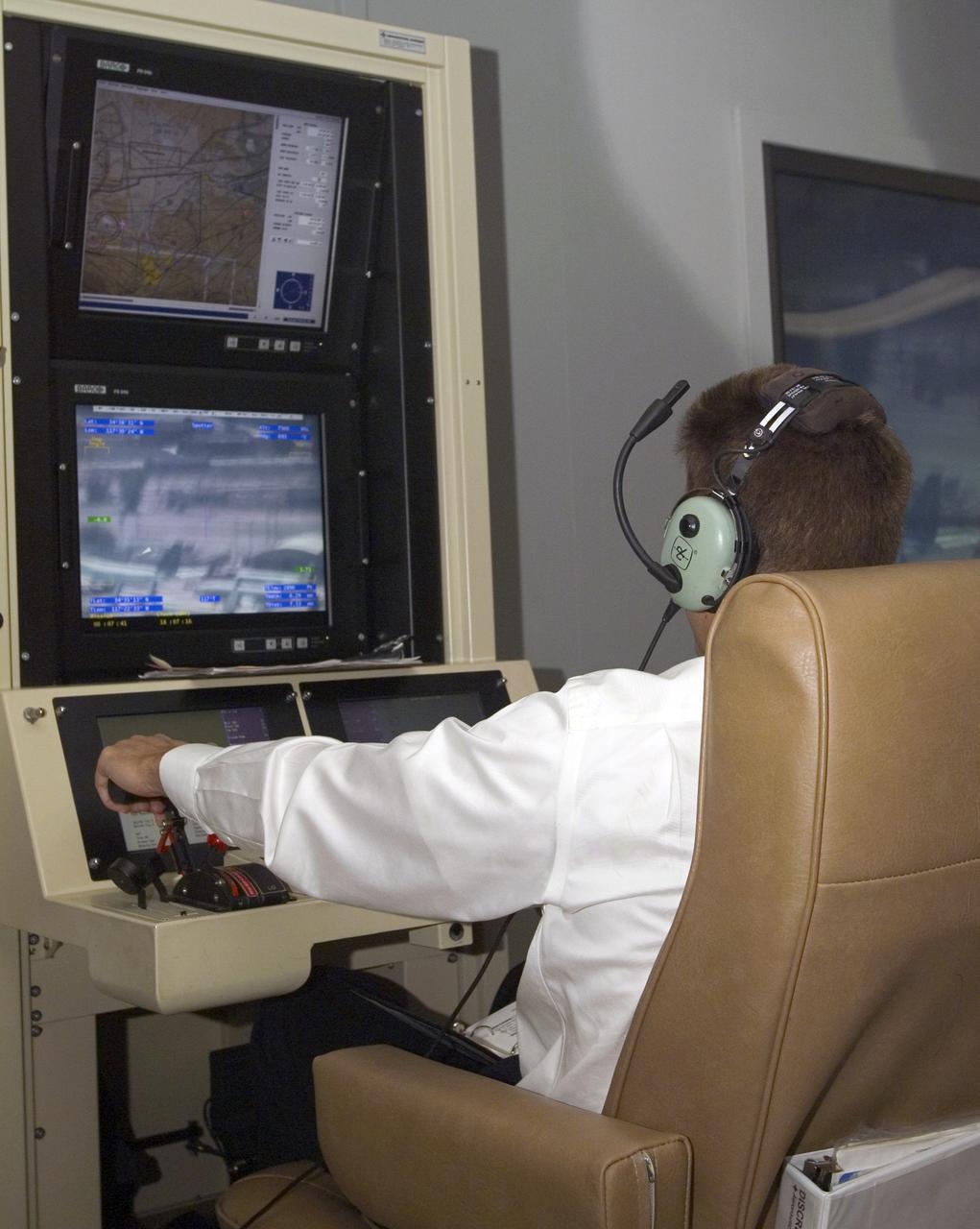 A pilot for General Atomics guides the Altair remotely operated aircraft from a ground control station using both visual and telemetered data.