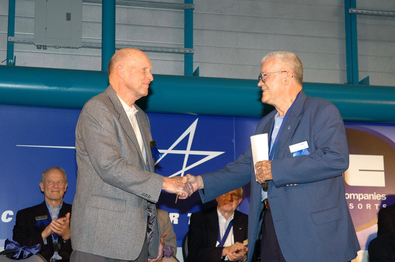 Former astronaut Gordon Fullerton (left), currently chief research pilot at NASA's Dryden Flight Research Center at Edwards Air Force Base, is congratulated by former astronaut Fred Haise (right) upon Fullerton's induction into the Astronaut Hall of Fame at the Kennedy Space Center (KSC) in Florida on April 30, 2005. Fullerton and Haise were one of two flight crews who flew the Approach and Landing Tests of the prototype Space Shuttle orbiter Enterprise at Dryden in 1977.  Fullerton, who had served on the support crews for four Apollo moon landing missions in the early 1970s, went on to fly two Shuttle missions, STS-3 in 1982 and STS-51F in 1985. STS-3 became the only Shuttle mission to date to land at White Sands, N.M., and STS-51F was completed successfully despite the failure of one of the Shuttle's main engines during ascent to orbit. Haise, a member of the crew on the ill-fated Apollo 13 mission, was also a research pilot at NASA Dryden during his pre-astronaut career.  Former astronauts Joseph Allen and Bruce McCandless were also inducted during the 2005 ceremonies at the KSC Visitor Center. In addition to honoring former members of NASA's astronaut corps who have made significant contributions to the advancement of space flight, the annual induction ceremonies serve as a fund-raiser for the Astronaut Scholarship Foundation. The foundation funded 17 $10,000 scholarships to college students studying science and engineering in 2004.