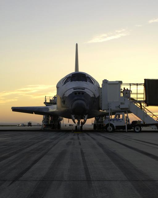 The sun rises on the Space Shuttle Discovery as it rests on the runway at Edwards Air Force Base, California, after a safe landing August 9, 2005