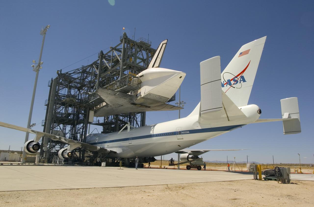 NASA's specially modified 747 Shuttle Carrier Aircraft, or SCA, is positioned under the Space Shuttle Discovery to be attached for their ferry flight to the Kennedy Space Center in Florida. After its post-flight servicing and preparation at NASA Dryden in California, Discovery's return flight to Kennedy aboard the 747 will take approximately 2 days, with stops at several intermediate points for refueling. Space Shuttle Discovery landed safely at NASA's Dryden Flight Research Center at Edwards Air Force Base at 5:11:22 a.m. PDT, August 9, 2005, following the very successful 14-day STS-114 return to flight mission.  During their two weeks in space, Commander Eileen Collins and her six crewmates tested out new safety procedures and delivered supplies and equipment the International Space Station.  Discovery spent two weeks in space, where the crew demonstrated new methods to inspect and repair the Shuttle in orbit. The crew also delivered supplies, outfitted and performed maintenance on the International Space Station. A number of these tasks were conducted during three spacewalks.  In an unprecedented event, spacewalkers were called upon to remove protruding gap fillers from the heat shield on Discovery's underbelly. In other spacewalk activities, astronauts installed an external platform onto the Station's Quest Airlock and replaced one of the orbital outpost's Control Moment Gyroscopes.  Inside the Station, the STS-114 crew conducted joint operations with the Expedition 11 crew. They unloaded fresh supplies from the Shuttle and the Raffaello Multi-Purpose Logistics Module. Before Discovery undocked, the crews filled Raffeallo with unneeded items and returned to Shuttle payload bay.  Discovery launched on July 26 and spent almost 14 days on orbit.