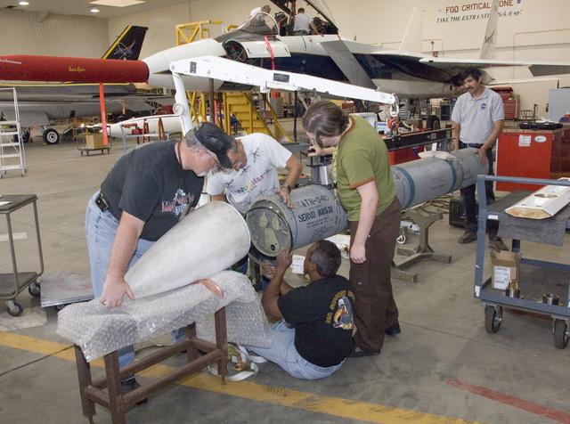 NASA image: NASA Dryden aircraft and avionics technicians install the nose cone on an inert Phoenix missile prior to a fit check on the center's F-15B research aircraft.