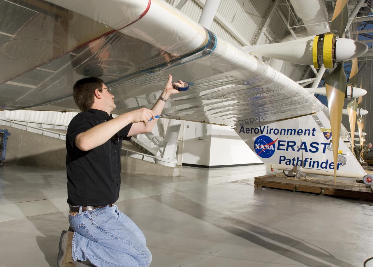 AeroVironment crew chief Mark Shipley applies sealing tape to a wing joint on Pathfinder-Plus before it is hoisted into place at the NASM's Udvar-Hazy Center.