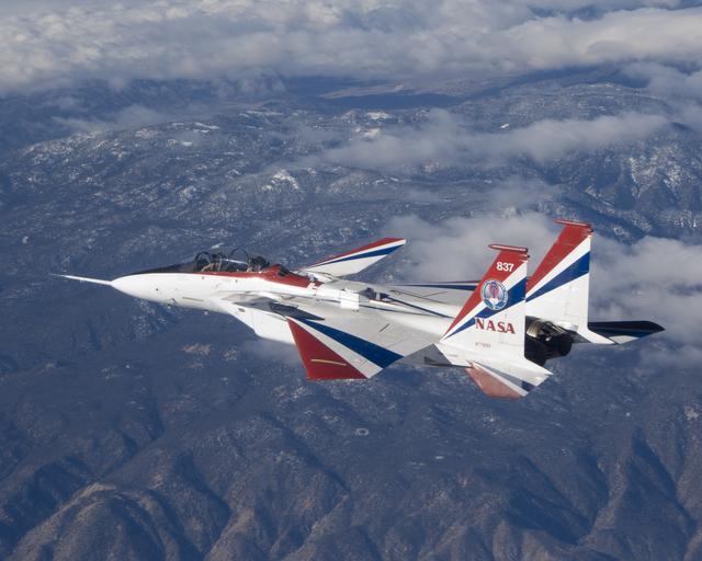 NASA image: The jagged ridges of Southern California's Tehachapi Mountains form the backdrop to NASA's brightly-colored NF-15B testbed aircraft during a research mission.