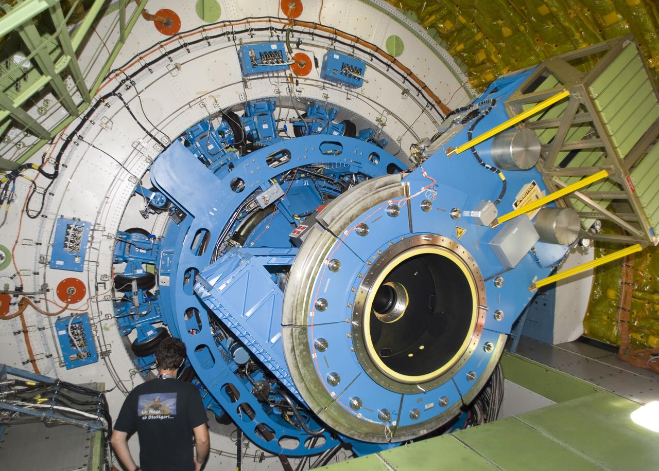 A technician examines the instrument mounting structure and bulkhead of the German-built infrared telescope installed in NASA's SOFIA airborne observatory.