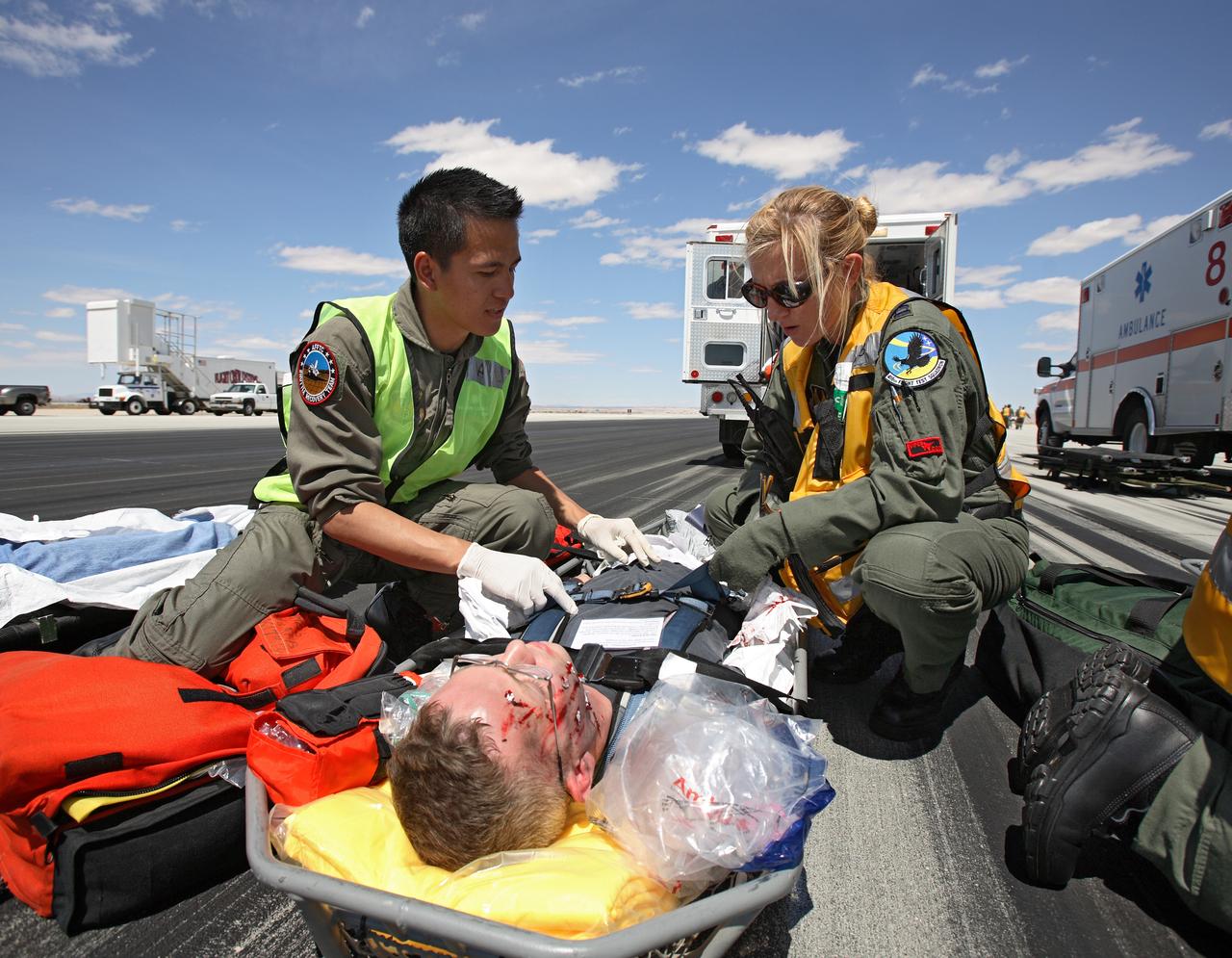 Complete with makeup to simulate facial injuries, a volunteer "astronaut" is tended to by aeromedical rescue staff after evacuation from the shuttle mockup. (USAF photo # 070505-F-1287F-145)
