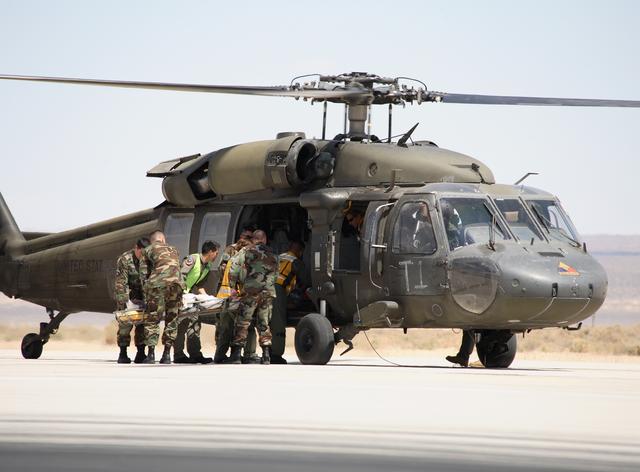Air Force rescue team members load the volunteer "injured astronaut" on a stretcher into a helicopter for evacuation to a hospital during the exercise