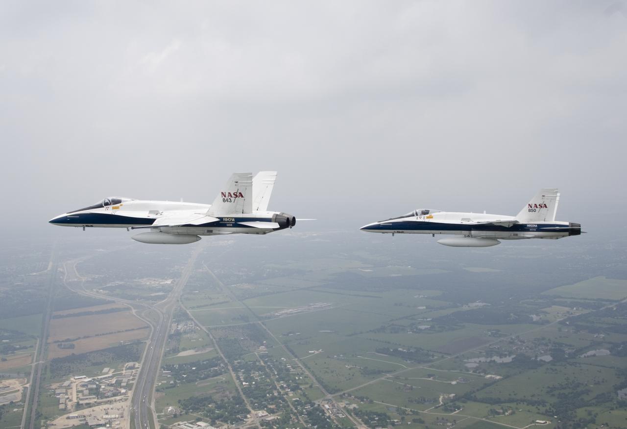 Two NASA F/A-18s flown by NASA Dryden research pilots Jim Smolka and Nils Larson cruise over the Texas landscape after supporting a SOFIA check flight in May 2007.