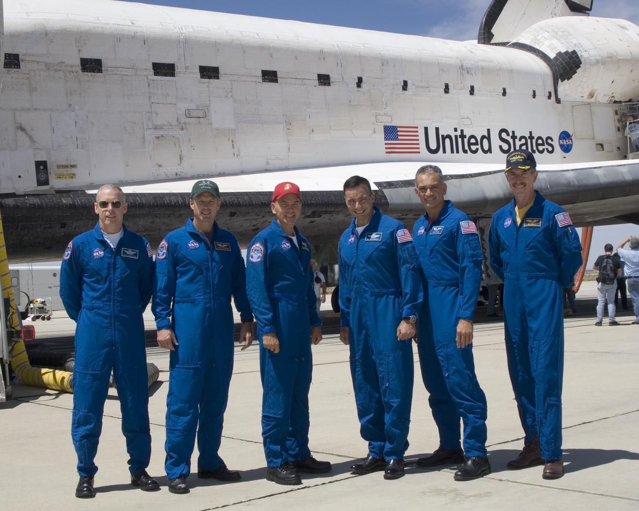 The crew of Space Shuttle mission STS-117 gathered in front of the shuttle Atlantis following landing at Edwards Air Force Base, California, June 22, 2007. From left to right: mission specialists Patrick Forrester and Steven Swanson, Commander Frederick Sturckow, Pilot Lee Archambault, and mission specialists John D. Olivas and James Reilly II.