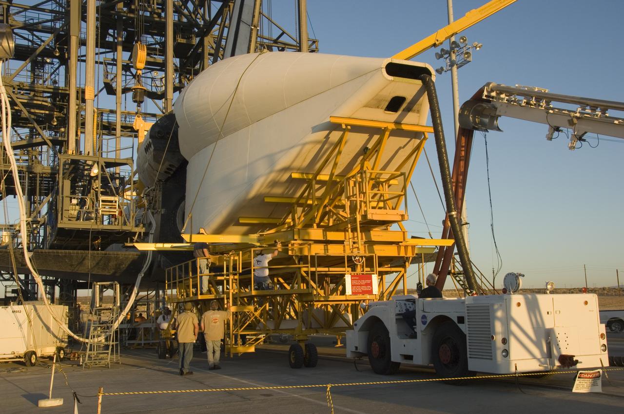 Technicians attach the tail cone, which helps reduce aerodynamic drag and turbulence during its ferry flight, to the Space Shuttle Atlantis in preparation for its return to NASA's Kennedy Space Center in Florida. After the tail-cone is installed, Discovery will be mounted on NASA's modified Boeing 747 Shuttle Carrier Aircraft, or SCA, for the return flight.