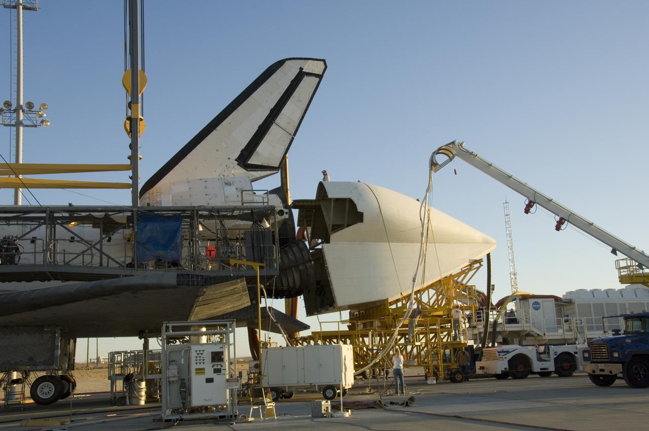 Technicians attach the tail cone, which helps reduce aerodynamic drag and turbulence during its ferry flight, to the Space Shuttle Atlantis in preparation for its return to NASA's Kennedy Space Center in Florida. After the tail-cone is installed, Discovery will be mounted on NASA's modified Boeing 747 Shuttle Carrier Aircraft, or SCA, for the return flight.
