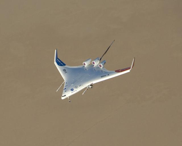 NASA image: The chocolate-colored expanse of Rogers Dry Lake frames the sleek lines of the Boeing / NASA X-48B subscale demonstrator during a test flight at Edwards AFB