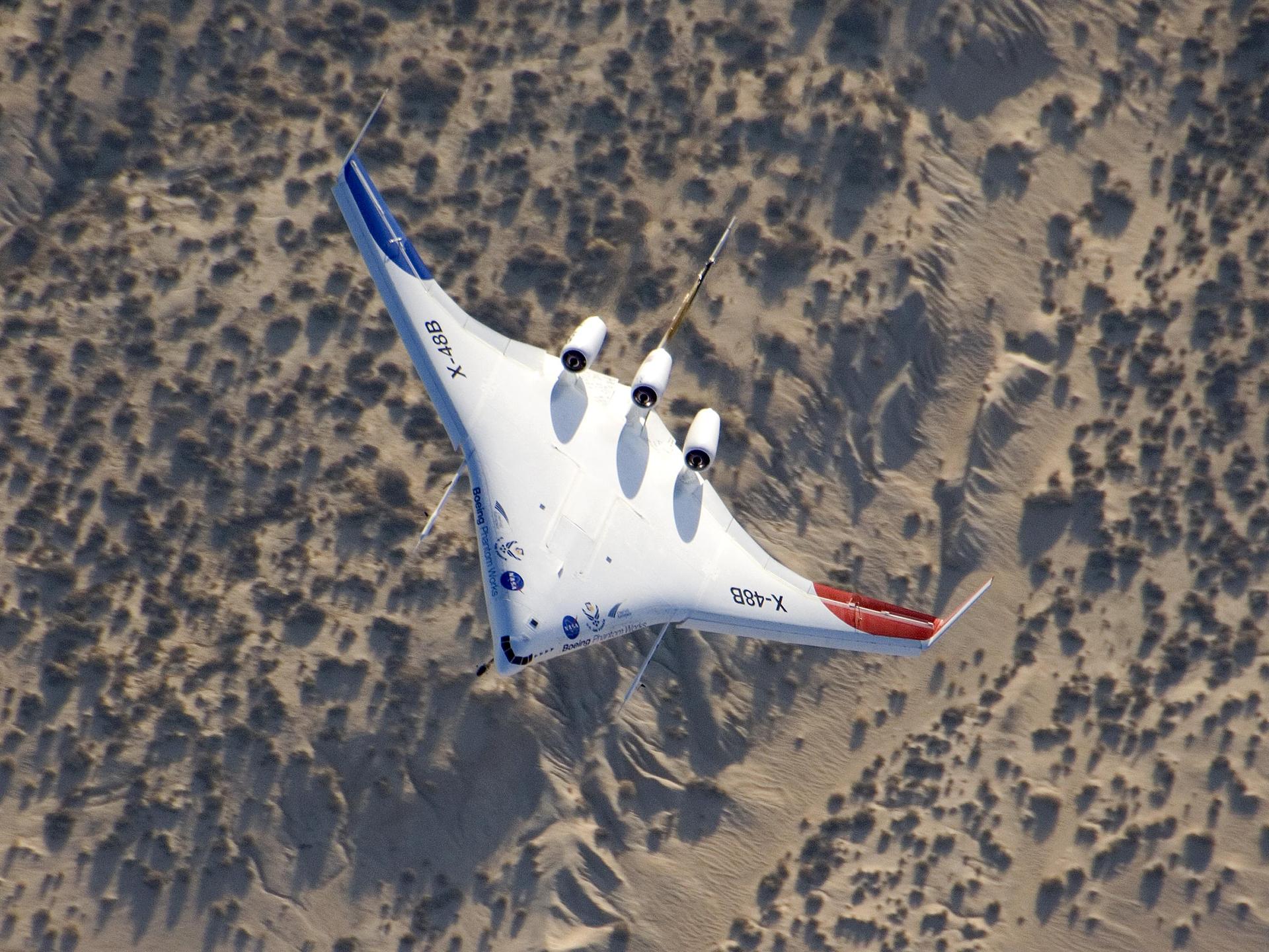 The unique X-48B Blended Wing Body subscale demonstrator banked over desert scrub at Edwards AFB during the aircraft's fifth test flight Aug. 14, 2007.