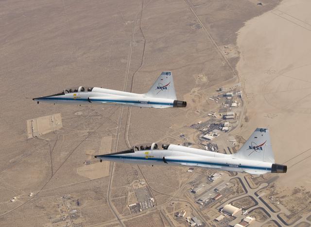 NASA Dryden's two T-38A mission support aircraft fly in tight formation while conducting a pitot-static airspeed calibration check near Edwards Air Force Base