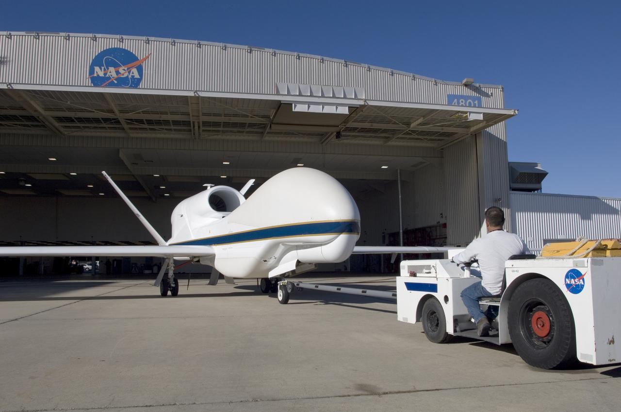A ground crewman maneuvers one of NASA's Global Hawk unmanned science aircraft into Hangar 4801 at NASA's Dryden Flight Research Center, Edwards, Calif.
