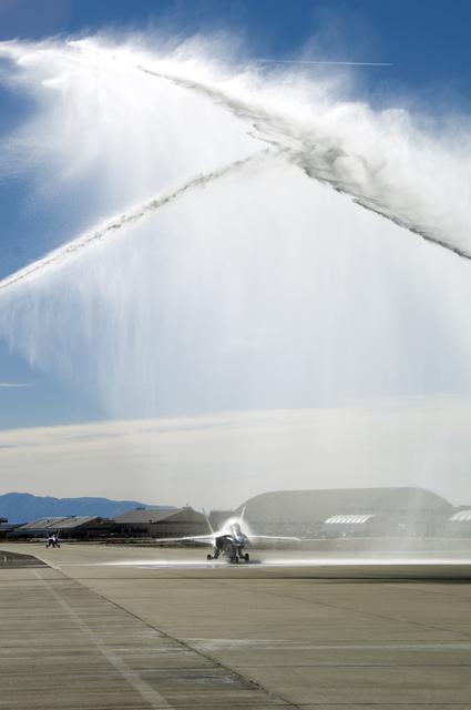 NASA image: A water-cannon salute from two Air Force fire trucks heralds NASA research pilot Gordon Fullerton's final mission as his NASA F/A-18 taxis beneath the spray.