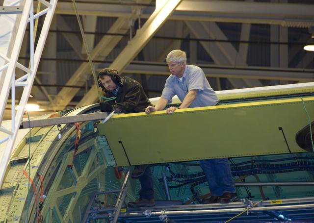 NASA image: Technicians carefully maneuver a spreader bar into place before removing the telescope aperture assembly from NASA's SOFIA infrared observatory Boeing 747SP