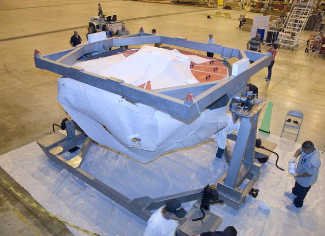 NASA image: SOFIA's primary mirror assembly is cradled on its dolly as technicians prepare to move it into a "clean room" at NASA Dryden's Aircraft Operations Facility