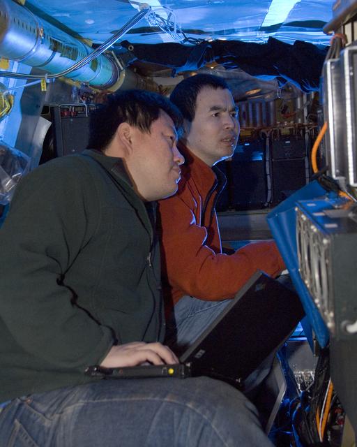 Jingqiu Moa and Xinrong Ren check out Pennsylvania State University's Airborne Tropospheric Hydrogen Oxides Sensor instrument during the ARCTAS mission upload