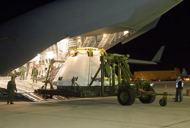 NASA image: Air Force loadmasters oversee unloading of the full-scale Orion abort test crew module mockup from a C-17 cargo aircraft at Edwards Air Force Base March 28.