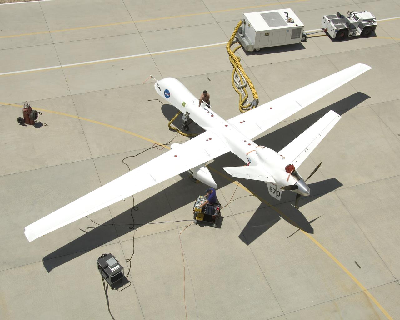 Ground crewmen prepare NASA's Ikhana remotely piloted research aircraft for another flight. Ikhana's infrared imaging sensor pod is visible under the left wing.