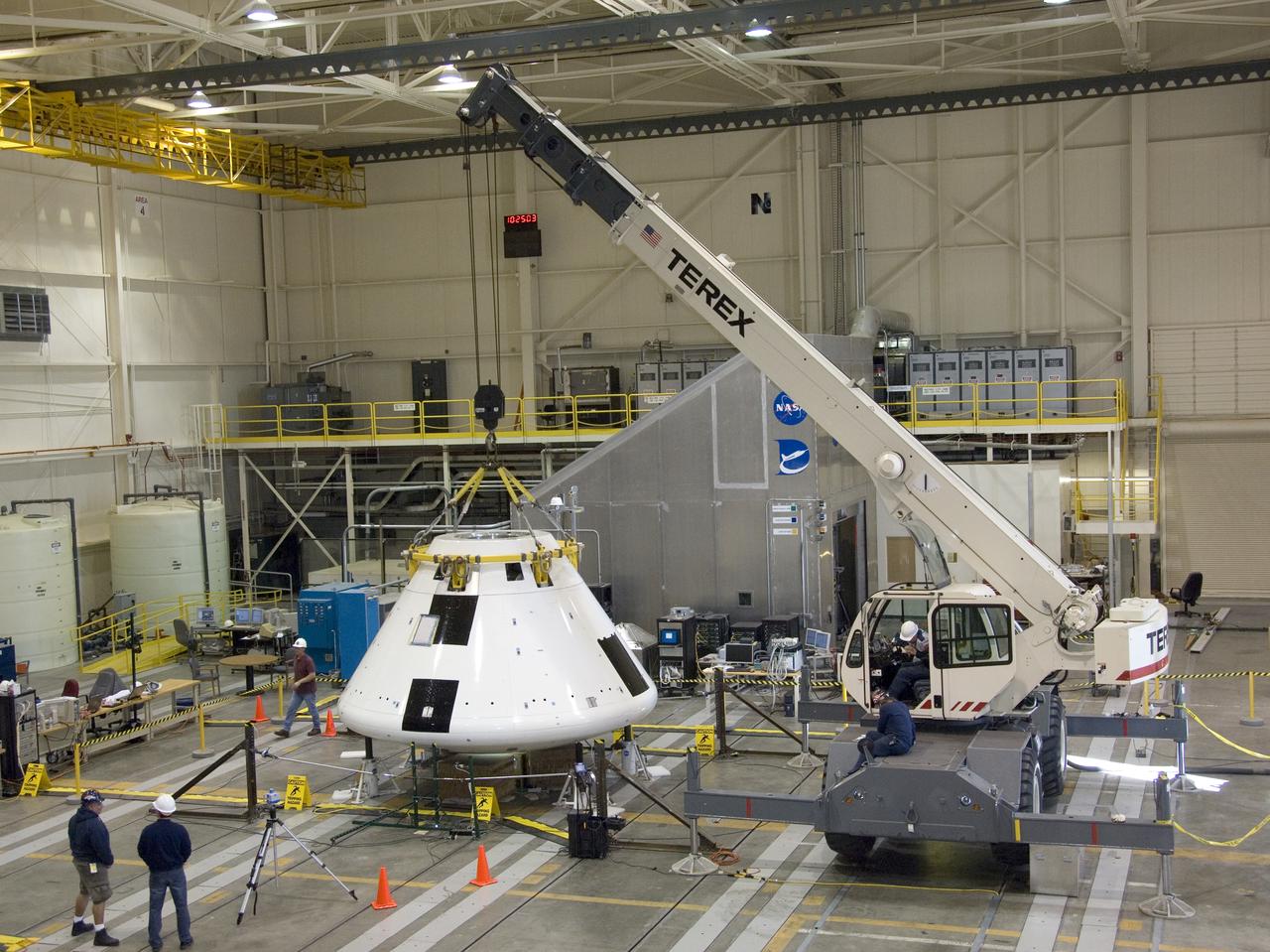 Under the watchful eyes of technicians, a crane positions the Orion PA-1 Abort Flight Test module for mass properties testing in NASA Dryden's Flight Loads Lab.