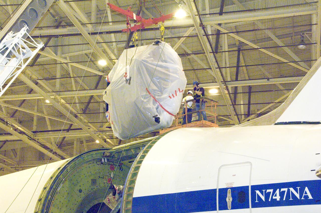 echnicians lift SOFIA's primary mirror assembly above NASA's 747SP airborne astronomy aircraft just prior to installation in the telescope cavity.