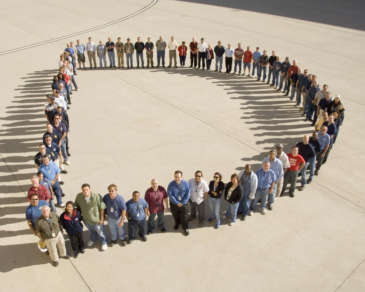 To support NASA's 50th Anniversary, NASA government and contractor employees gathered to form a giant "D" outside the Dryden Aircraft Operations Facility