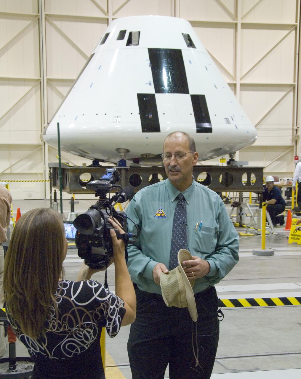 Reporter Julie Flannery of KERO-TV, Bakersfield, interviews NASA Dryden's Orion Abort Flight Test project manager Gary Martin in front of the Orion PA-1 crew module.
