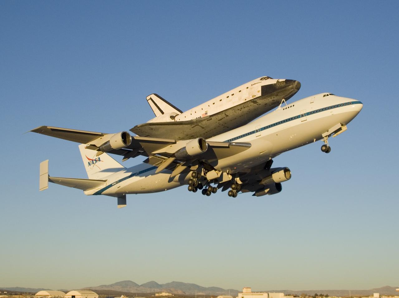 The modified Boeing 747 carrier aircraft carrying the Space Shuttle Endeavour soars aloft from Edwards Air Force Base on the first leg of its ferry flight back to the Kennedy Space Center just after sunrise on Dec. 10, 2008.