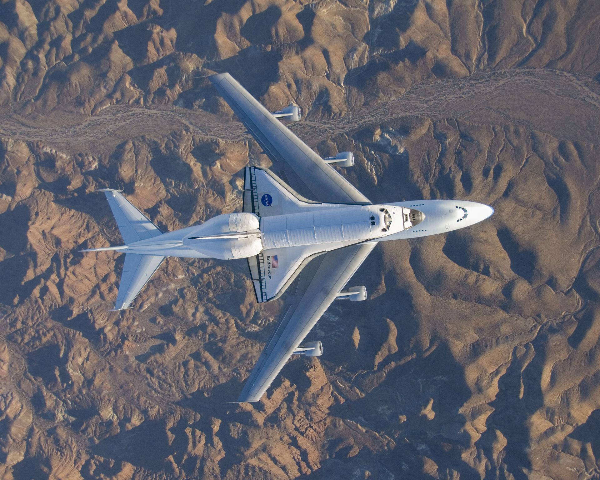 NASA aerial photographer Carla Thomas captured this top-down view of the Space Shuttle Endeavor mounted on a NASA 747 Shuttle Carrier Aircraft from an inverted F/A-18 on Wednesday, Dec. 10, 2008, over the Mojave Desert in California. The shuttle, returning to Kennedy Space Center in Florida, landed at Edwards Air Force Base in Edwards, California, and was prepared nearby at NASA’s Armstrong Flight Research Center for the return trip to Kennedy.