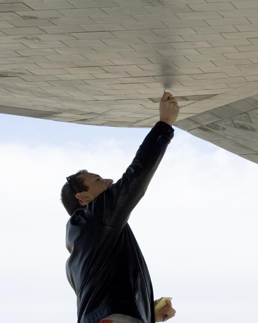 NASA image: A technician carefully checks the thermal tiles on the underside of Space Shuttle Endeavour for nicks and dings following its landing at Edwards Air Force Base