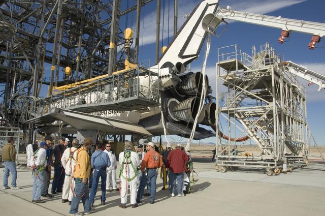 NASA image: Technicians gather around the rear of Space Shuttle Endeavour for a safety briefing prior to moving the tail workstand around the shuttle's engines