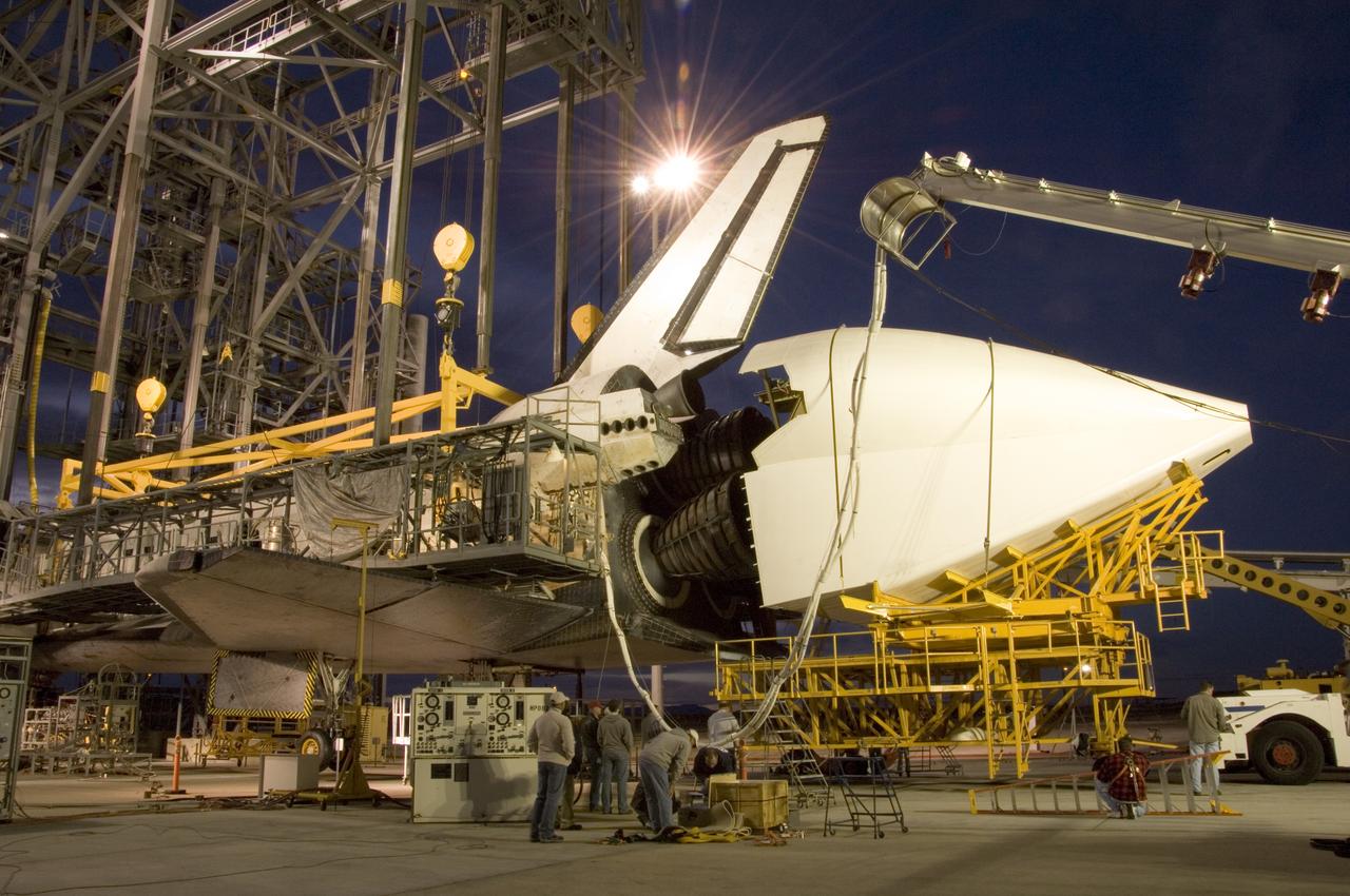 NASA technicians position the aerodynamic tailcone around the engine nozzles of the Space Shuttle Endeavour Dec. 7 in preparation for its ferry flight from NASA's Dryden Flight Research Center at Edwards Air Force Base back to the Kennedy Space Center in Florida.