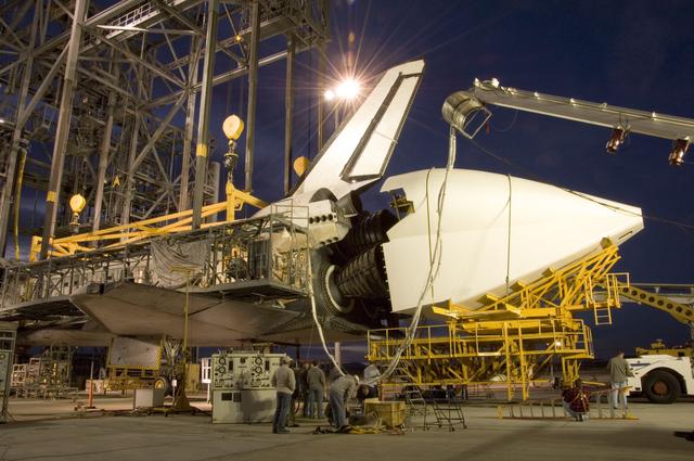 NASA image: NASA technicians position the aerodynamic tailcone around the engine nozzles of the Space Shuttle Endeavour in preparation for its ferry back to KSC in Florida