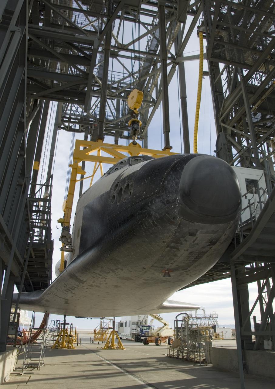 The Space Shuttle Endeavour is slowly hoisted aloft in the Mate-Demate gantry at NASA's Dryden Flight Research Center before being mounted atop its modified 747 carrier aircraft for a ferry flight back to the Kennedy Space Center in Florida.