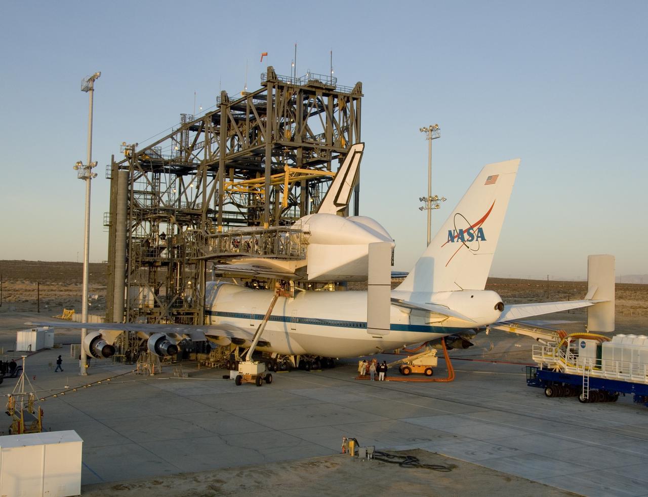 The Space Shuttle Endeavour and its modified Boeing 747 carrier aircraft are illuminated by the morning sun Tuesday after mating of the pair was completed overnight in the Mate-DeMate gantry at NASA Dryden Flight Research Center. The pair are scheduled to depart Edwards Air Force Base on their ferry flight back to the Kennedy Space Center early Wednesday morning, Dec. 10.