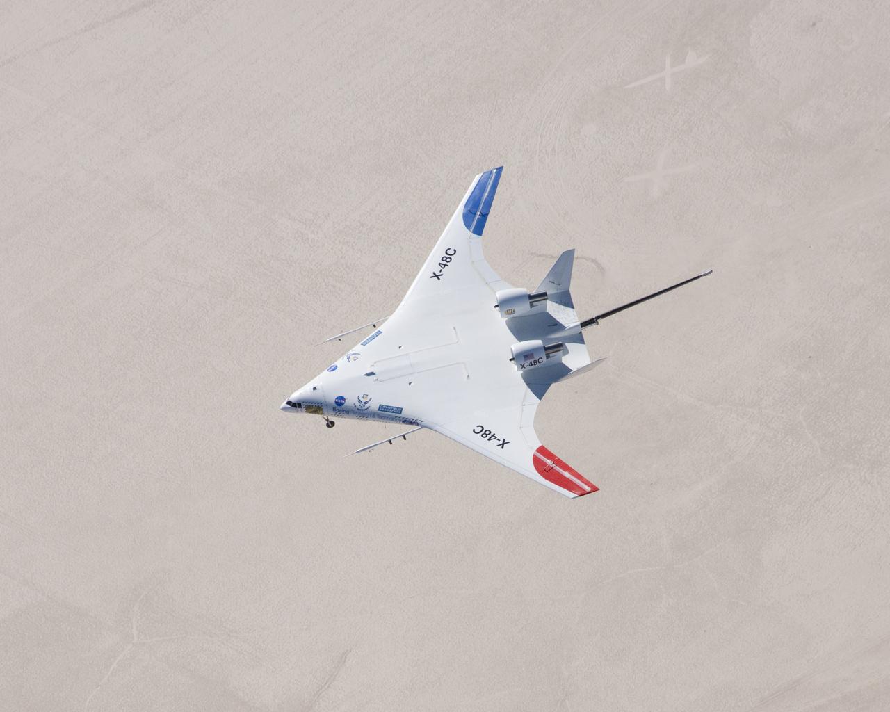 The X-48C Hybrid Wing Body aircraft flew over Rogers Dry Lake on Feb. 28, 2013, from NASA's Dryden Flight Research Center, Edwards, CA. The long boom protruding from between the tails was part of the aircraft's parachute-deployment flight termination system. 
