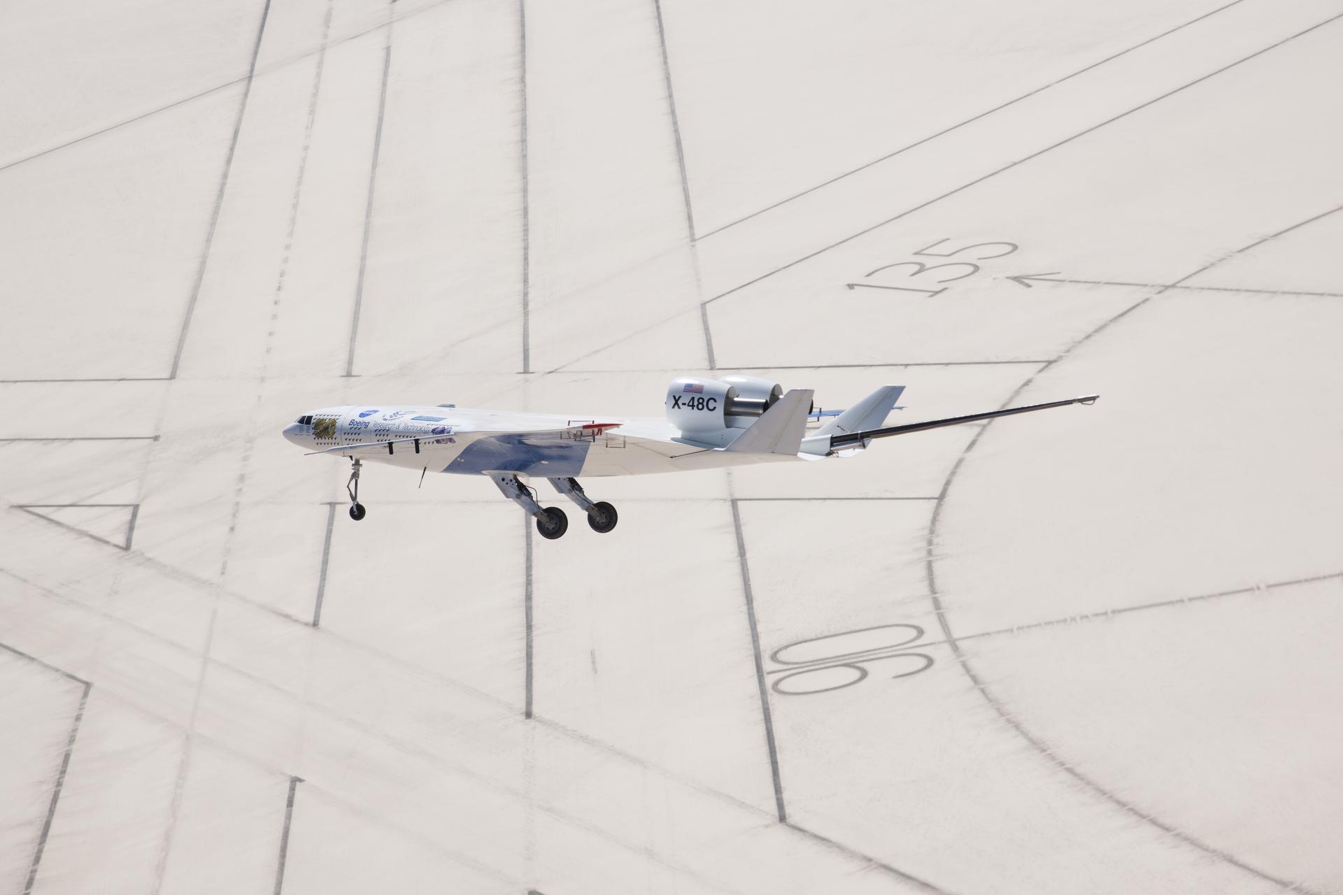 The X-48C Hybrid Wing Body research aircraft flew over the intersection of several runways adjacent to the compass rose on Rogers Dry Lake at Edwards Air Force Base during one of the sub-scale aircraft's final test flights on Feb. 28, 2013.