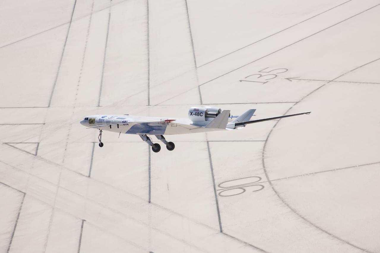 The X-48C Hybrid Wing Body research aircraft flew over the intersection of several runways adjacent to the compass rose on Rogers Dry Lake at Edwards Air Force Base during one of the sub-scale aircraft's final test flights on Feb. 28, 2013.