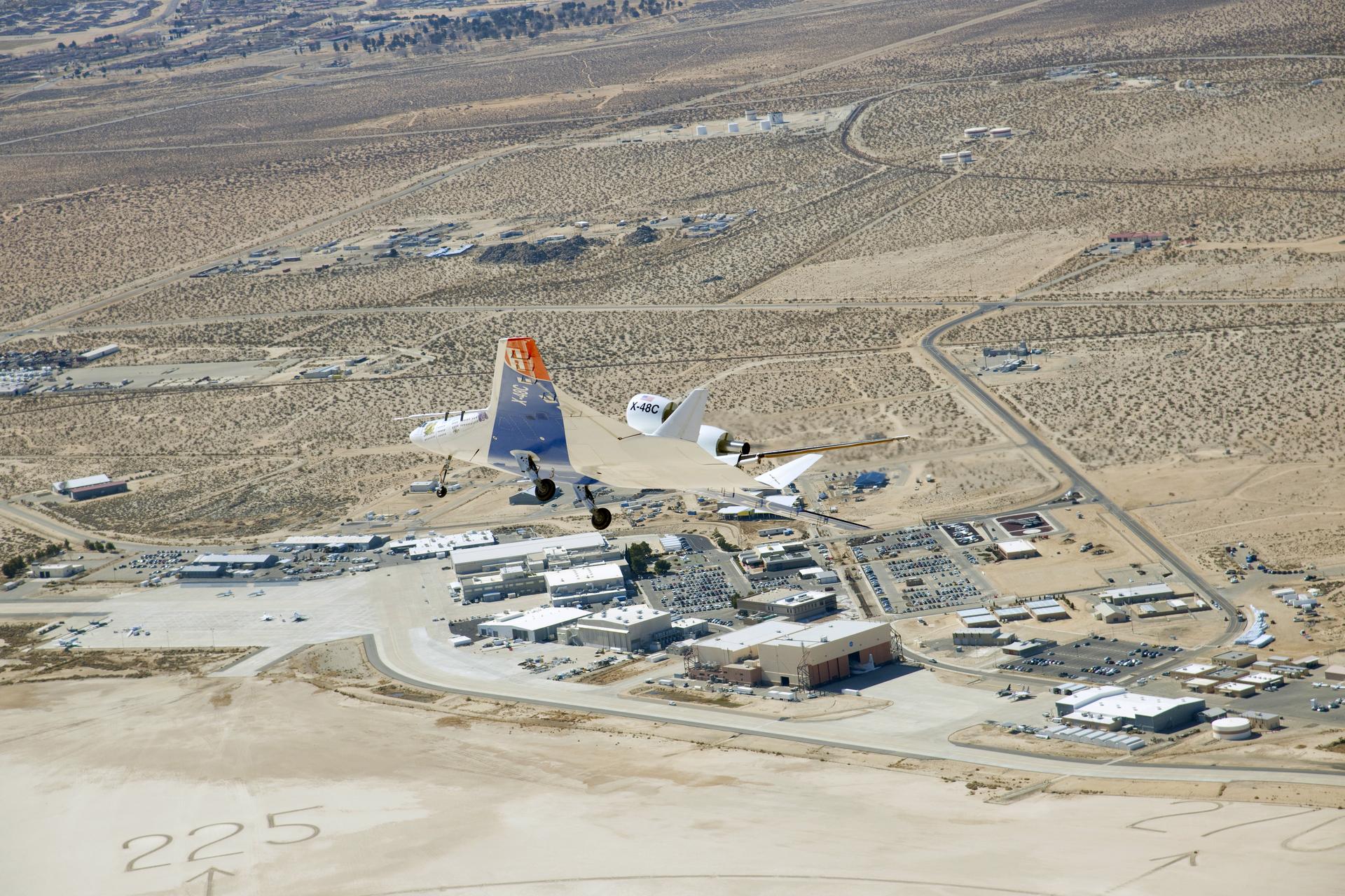 The X-48C Hybrid Wing Body research aircraft banked right over NASA's Dryden Flight Research Center at Edwards, CA.