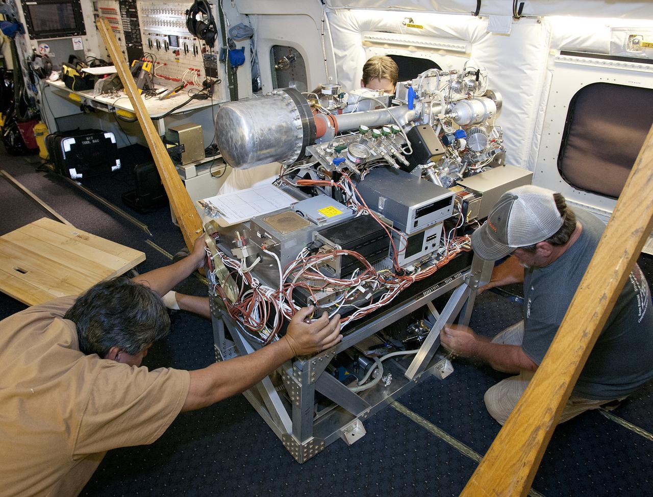 Scientists and technicians ready an instrument rack for mounting in NASA's DC-8 flying laboratory in preparation for a complex mission to study how air pollution and natural emissions affect climate change