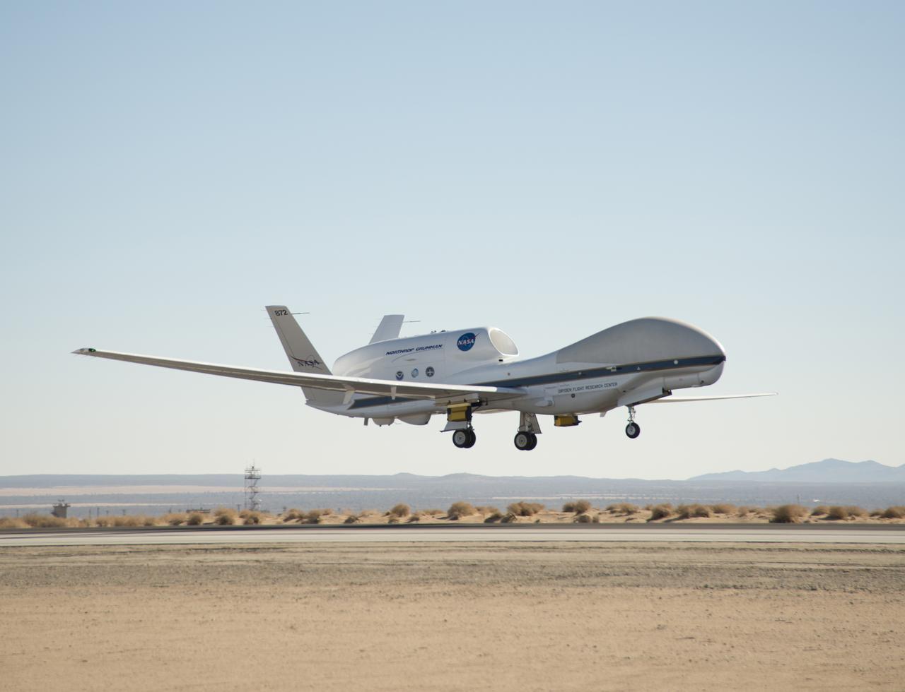 NASA's Global Hawk 872 lifted off the runway at Edwards Air Force Base during a checkout flight of instruments for the 2014 ATTREX mission over the western Pacific Ocean. Yellow and black pods housing the Hawkeye cloud particle probe instruments being used during the mission can be seen underneath the wings.