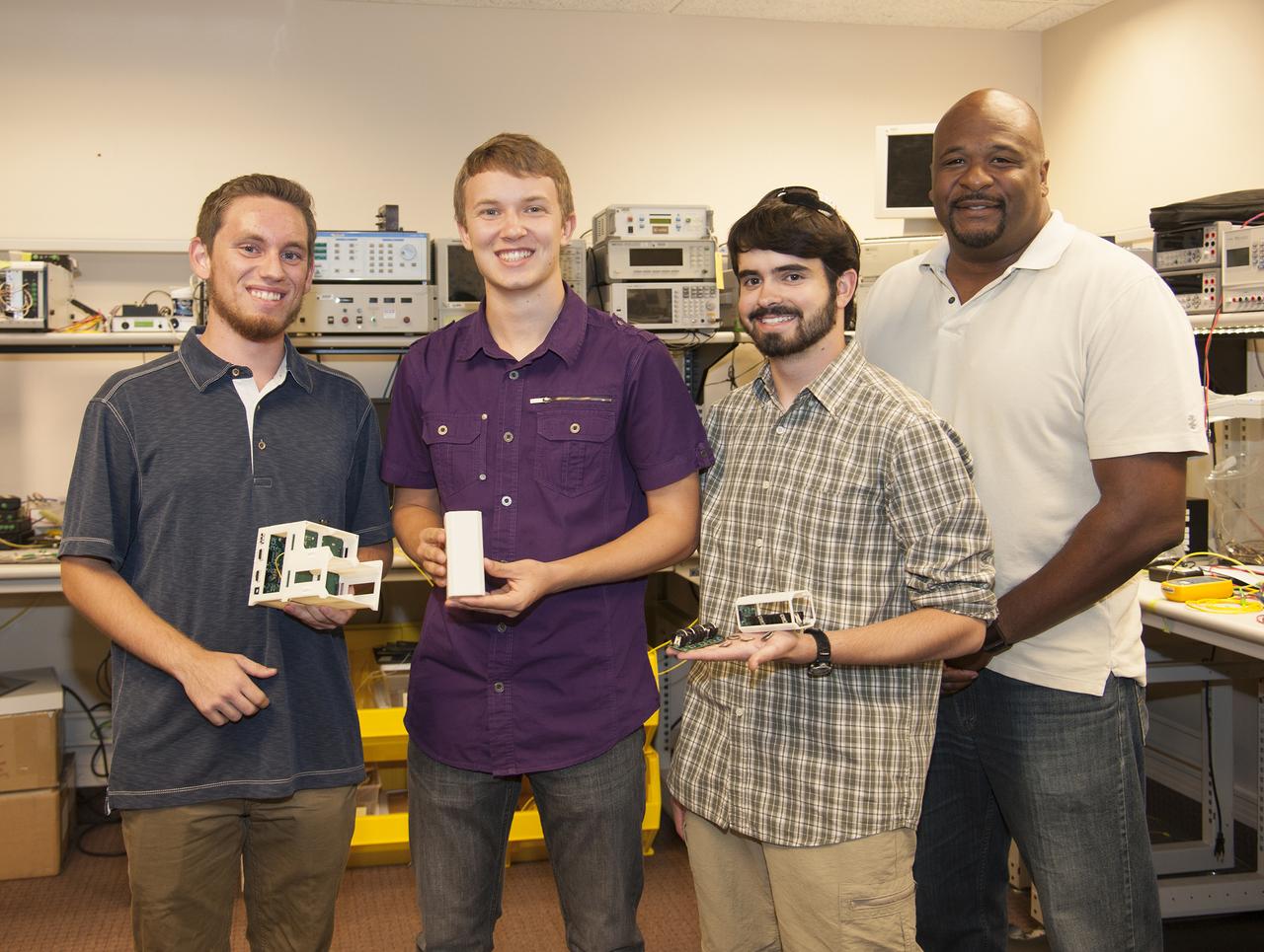 From left, former Desert Christian students Logan Francisco, Kyler Stephens and Jonathan Lokos and NASA Armstrong mentor Allen Parker show the elements of the experiment launched into space on Dec. 3.