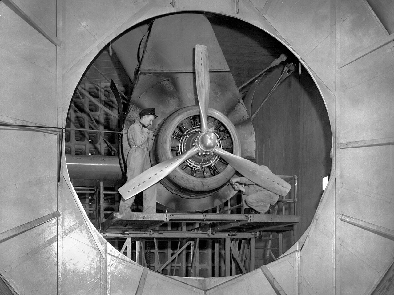 A Wright Aeronautical R–2600 Cyclone piston engine installed in the Engine Propeller Research Building, or Prop House, at the National Advisory Committee for Aeronautics (NACA) Aircraft Engine Research Laboratory.  The R–2600 was among the most powerful engines that emerged during World War II. The engine, which was developed for commercial applications in 1939, was used to power the North American B–25 bomber and several other midsize military aircraft. The higher altitudes required by the military caused problems with the engine's cooling and fuel systems.        The military requested that the Aircraft Engine Research Laboratory analyze the performance of the R–2600, improve its cooling system, and reduce engine knock. The NACA researchers subjected the engine to numerous tests in its Prop House. The R–2600 was the subject of the laboratory's first technical report, which was written by members of the Fuels and Lubricants Division.    The Prop House contained soundproof test cells in which piston engines and propellers were mounted and operated at high powers. Electrically driven fans drew air through ducts to create a stream of cooling air over the engines. Researchers tested the performance of fuels, turbochargers, water-injection and cooling systems here during World War II. The facility was also investigated a captured German V–I buzz bomb during the war.