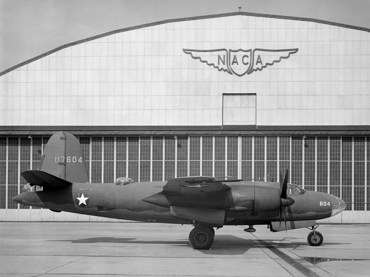 The Aircraft Engine Research Laboratory’s first aircraft, a Martin B–26B Marauder, parked in front of the Flight Research Building in September 1943. The military loaned the B–26B to the National Advisory Committee for Aeronautics (NACA) to augment the lab’s studies of the Wright Aeronautical R–2800 engines. The military wanted to improve the engine cooling in order to increase the bomber’s performance. On March 17, 1943, the B–26B performed the very first research flight at the NACA’s new engine laboratory.   The B–26B received its “Widowmaker” nickname during the rushed effort to transition the new aircraft from design to production and into the sky. During World War II, however, the B–26B proved itself to be a capable war machine. The U.S. lost fewer Marauders than any other type of bomber employed in the war. The B–26B was originally utilized at low altitudes in the Pacific but had its most success at high altitudes over Europe.    The B–26B’s flight tests in Cleveland during 1943 mapped the R-2800 engine’s behavior at different altitudes and speeds. The researchers were then able to correlate engine performance in ground facilities to expected performance at different altitudes. They found that air speed, cowl flap position, angle of attack, propeller thrust, and propeller speed influenced inlet pressure recovery and exhaust distribution. The flight testing proceeded quickly, and the B–26B was transferred elsewhere in October 1943.