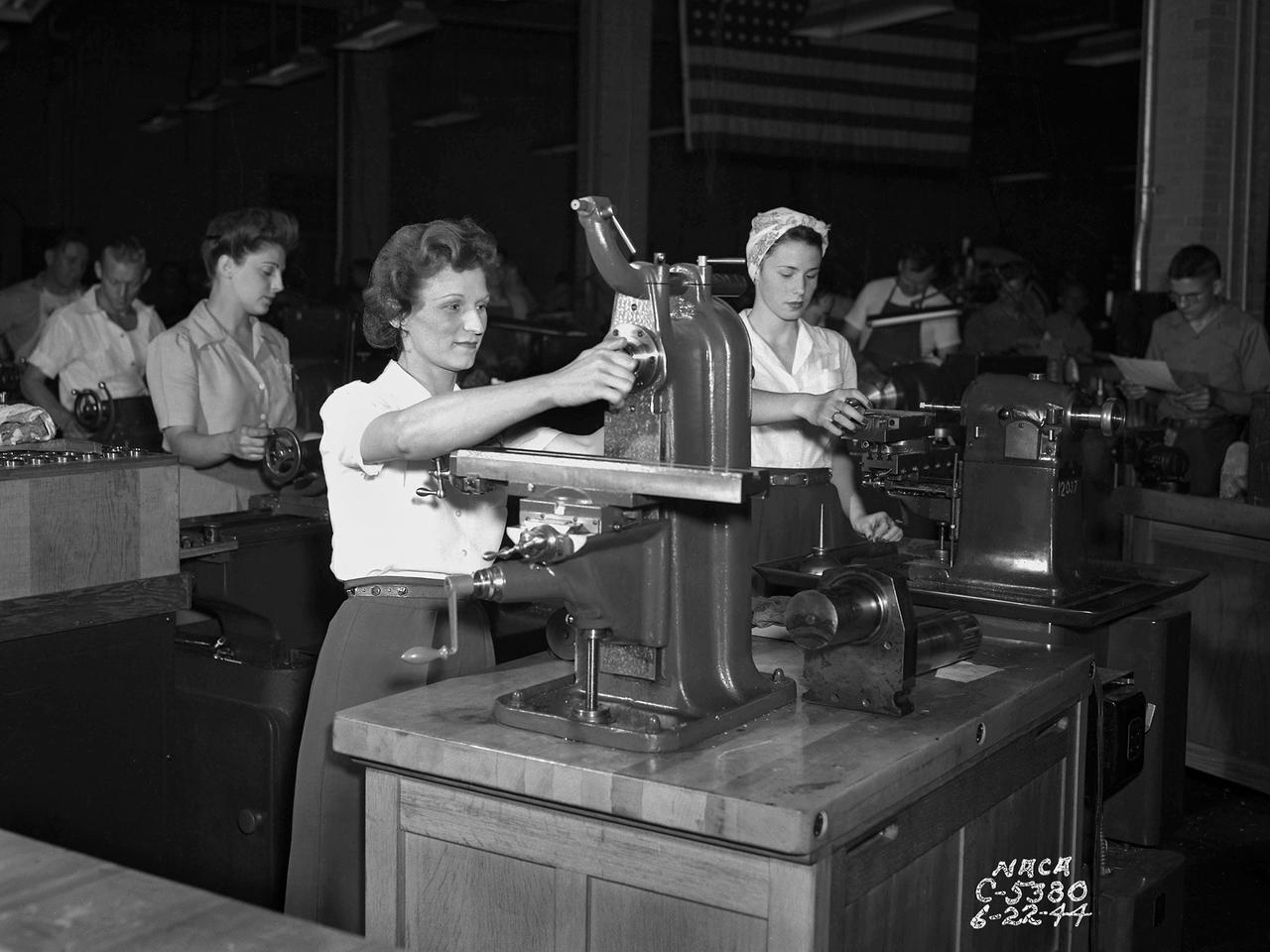 The loss of male NACA employees to the war effort and the military’s increased demand for expedited aeronautical research results resulted in a sharp demand for increased staffing in the early 1940s. The Aircraft Engine Research Laboratory (AERL) undertook an extensive recruiting effort to remedy the situation. Current employees were asked to bring in friends and family members, including women. The number of women employed at the AERL nearly doubled to 412 between 1943 and 1944.    In May 1944 Director Raymond Sharp initiated a program to train women as machine operators, electricians, instrumentation engineers, and other technical positions. The move coincided with the lab’s implementation of a third shift to meet the military’s demands for improved aircraft performance. There was also a modest, but important, number of female engineers and chemists, as well as large group employed in more traditional positions such as data analysts, editors, and clerks.     The integration of women in the research process was critical. Researchers developed a test and submitted plans to the Drafting Section to be converted into blueprints. In some instances the Instrumentation Shop was asked to create instruments for the test. During the test, computers gathered and analyzed the data. The researcher then wrote the report which was reviewed by the Editorial Department and printed in the Duplication Unit. All of these tasks were generally performed by female employees.
