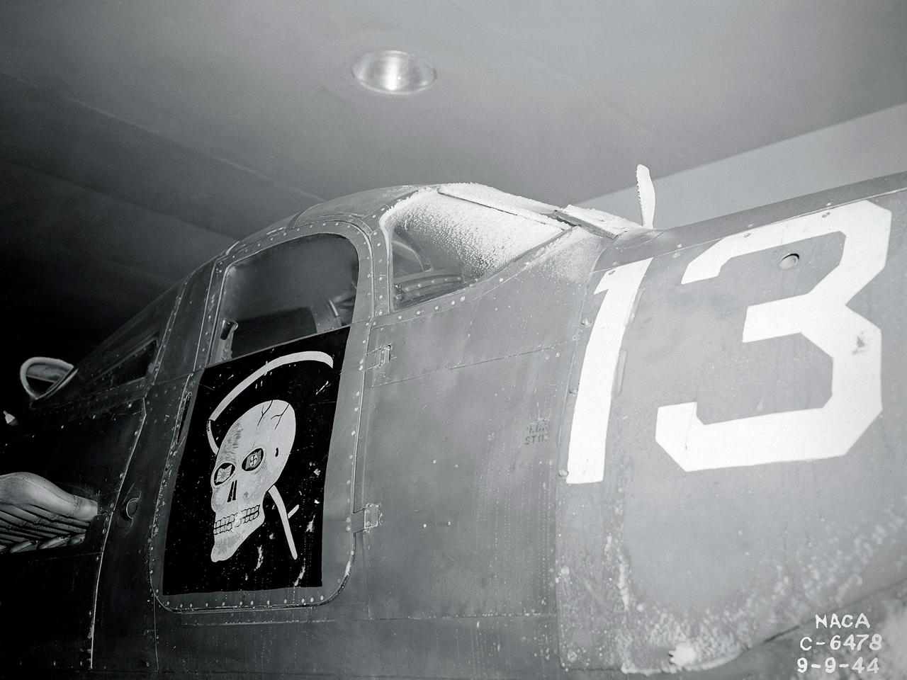 A Bell P-39 Airacobra in the NACA Aircraft Engine Research Laboratory’s Icing Research Tunnel for a propeller deicing study. The tunnel, which began operation in June 1944, was built to study the formation of ice on aircraft surfaces and methods of preventing or eradicating that ice. Ice buildup adds extra weight to aircraft, effects aerodynamics, and sometimes blocks airflow through engines.     NACA design engineers added the Icing Research Tunnel to the new AERL’s original layout to take advantage of the massive refrigeration system being constructed for the Altitude Wind Tunnel. The Icing Research Tunnel is a closed-loop atmospheric wind tunnel with a 6- by 9-foot test section. The tunnel can produce speeds up to 300 miles per hour and temperatures from about 30 to –45⁰ F.  During World War II AERL researchers analyzed different ice protection systems for propeller, engine inlets, antennae, and wings in the icing tunnel. The P-39 was a vital low-altitude pursuit aircraft of the US during the war. NACA investigators investigated several methods of preventing ice buildup on the P-39’s propeller, including the use of internal and external electrical heaters, alcohol, and hot gases. They found that continual heating of the blades expended more energy than the aircraft could supply, so studies focused on intermittent heating. The results of the wind tunnel investigations were then compared to actual flight tests on aircraft.