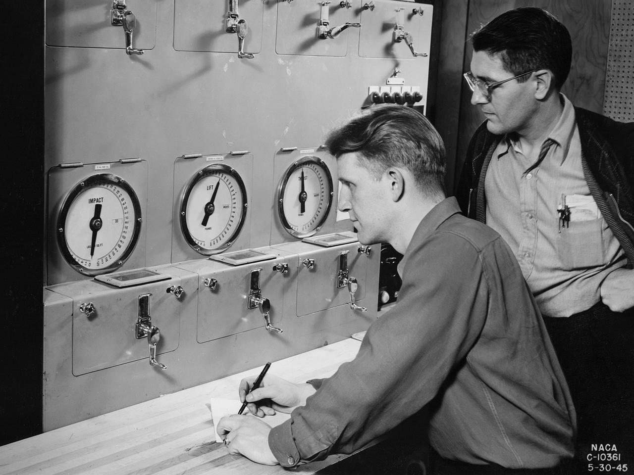 Researchers at the National Advisory Committee for Aeronautics (NACA) Aircraft Engine Research Laboratory monitor a ramjet's performance in the Altitude Wind Tunnel from the control room. The soundproof control room was just a few feet from the tunnel’s 20-foot-diameter test section. In the control room, the operators could control all aspects of the tunnel’s operation, including the air density, temperature, and speed. They also operated the engine or test article in the test section by controlling the angle-of-attack, speed, power, and other parameters. The men in this photograph are monitoring the engine’s thrust and lift.   A NACA-designed 20-inch-diameter ramjet was installed in the tunnel in May 1945. Thrust figures from these runs were compared with drag data from tests of scale models in small supersonic tunnels to verify the ramjet’s feasibility. The tunnel was used to analyze the ramjet’s overall performance up to altitudes of 47,000 feet and speeds to Mach 1.84. The researchers found that an increase in altitude caused a reduction in the engine’s horsepower and identified optimal flameholder configurations.