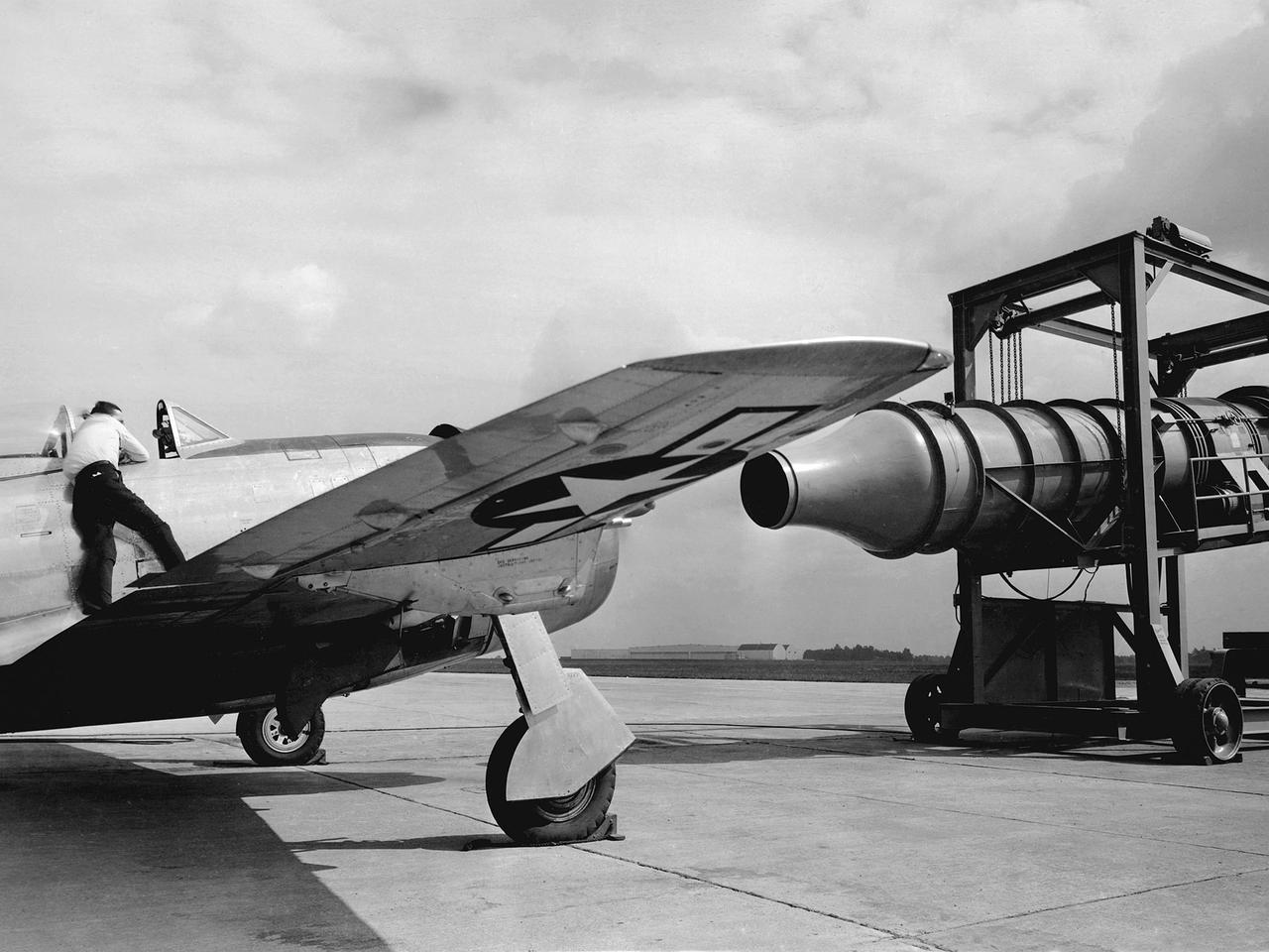 A Republic P-47G Thunderbolt is tested with a large blower on the hangar apron at the National Advisory Committee for Aeronautics (NACA) Aircraft Engine Research Laboratory in Cleveland, Ohio. The blower could produce air velocities up to 250 miles per hour. This was strong enough to simulate take-off power and eliminated the need to risk flights with untried engines.     The Republic P-47G was loaned to the laboratory to test NACA modifications to the Wright R-2800 engine’s cooling system at higher altitudes. The ground-based tests, seen here, were used to map the engine’s normal operating parameters. The P-47G then underwent an extensive flight test program to study temperature distribution among the engine’s 18 cylinders and develop methods to improve that distribution.